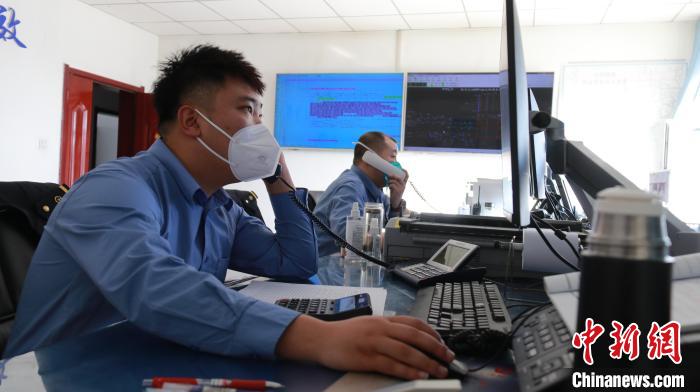 圖為貨運調度人員與外勤工作人員聯(lián)系掌握車輛裝載情況?！±钌?攝