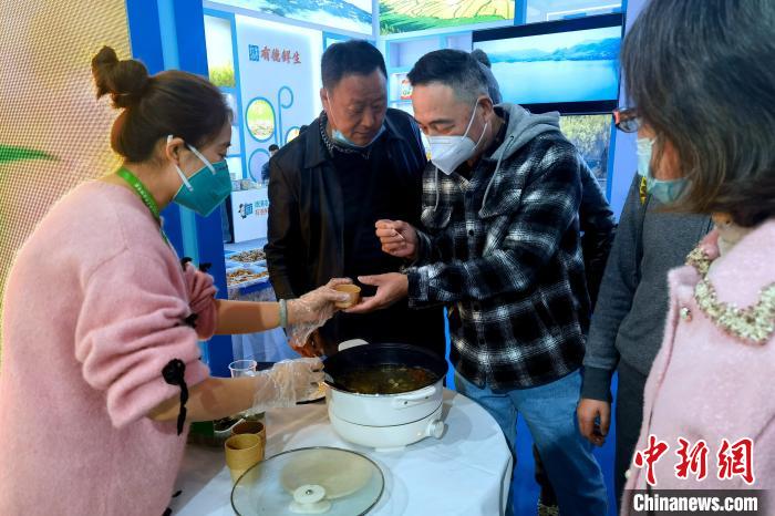 圖為杭州市民品嘗茶卡羊肉?！±铍h 攝