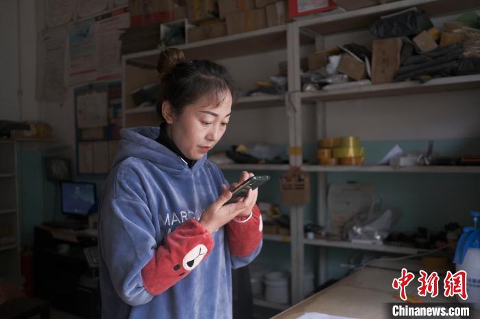 正在快遞站點(diǎn)內(nèi)忙碌的楊莉春。　何蓬磊 攝