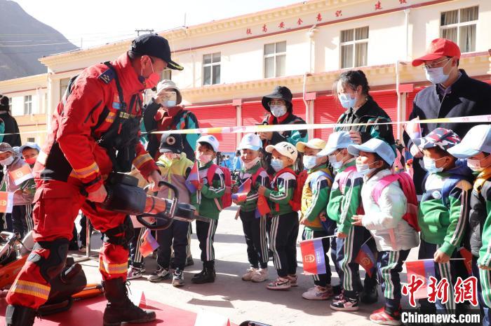 圖為消防指戰(zhàn)員為學(xué)生講解、演示先進(jìn)救援裝備?！≮w琳 攝