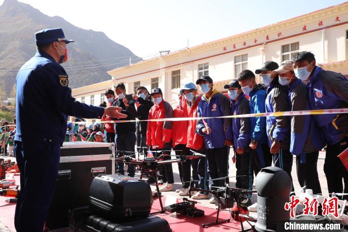 圖為消防指戰(zhàn)員為學(xué)生講解、演示先進(jìn)救援裝備?！≮w琳 攝