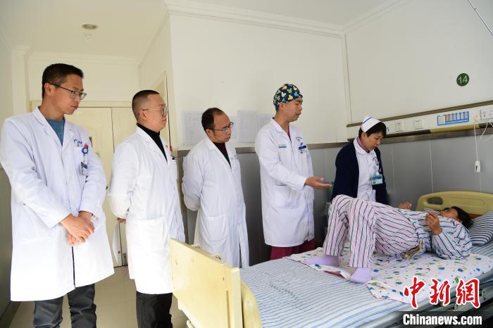 圖為何蔚副主任醫(yī)師(站右二)及團隊術(shù)后指導患者進行腰背肌鍛煉。　貢嘎來松 攝