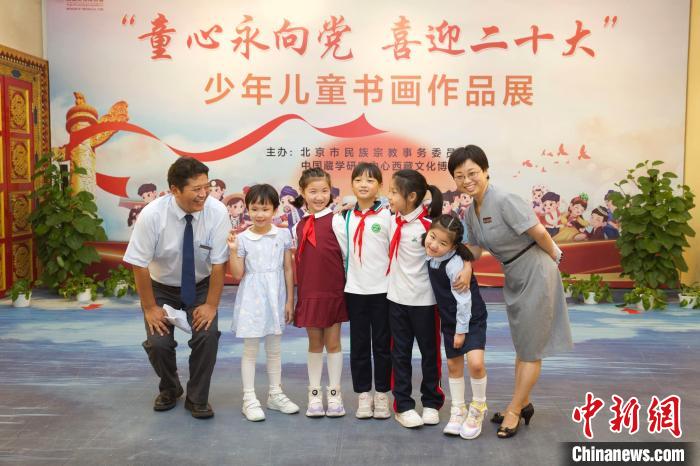 圖為與會(huì)嘉賓與入選畫(huà)作的“小作者”們?cè)谡褂[上合影?！≈袊?guó)藏學(xué)研究中心供圖