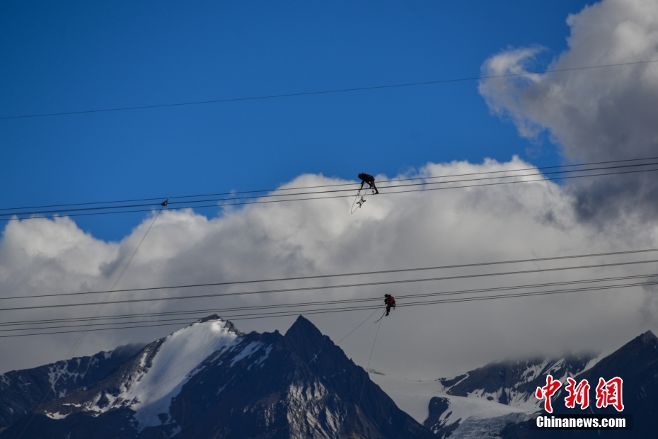 資料圖為2020年6月23日，西藏阿里聯(lián)網(wǎng)工程施工人員在日喀則希夏邦馬雪山附近進行走線作業(yè)，安裝絕緣設(shè)備。 <a target='_blank' href='/'><p  align=