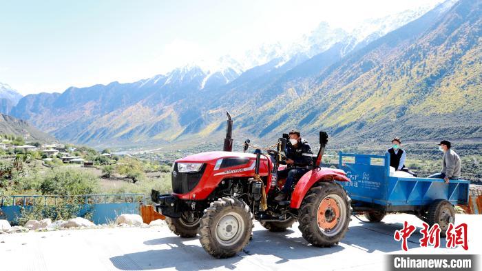 圖為工作人員將把加工完成的糌粑運(yùn)送至村民手中。　嘉黎縣融媒體中心供圖