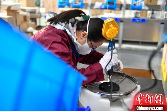 圖為工人正在組裝炊具。　貢嘎來松 攝