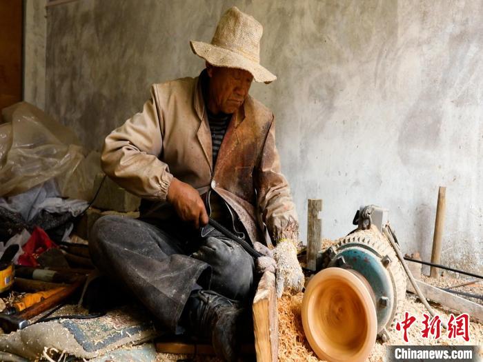 圖為手工藝人正在制作木碗?！?鄧海平 攝