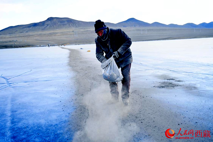 牧民在冰面上撒灰鋪成通道。人民網(wǎng) 李海霞攝