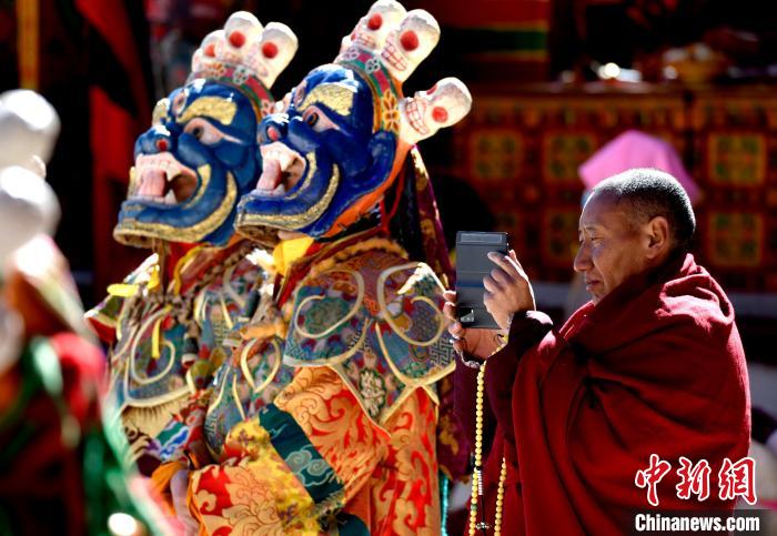 2月19日，正在拍攝跳神活動(dòng)的僧人?！±盍?攝