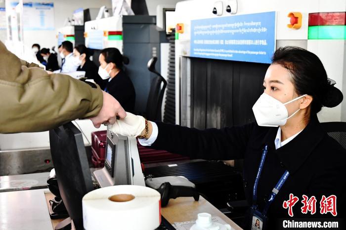 圖為機場工作人員為旅客辦理行李托運?！≈芎?攝