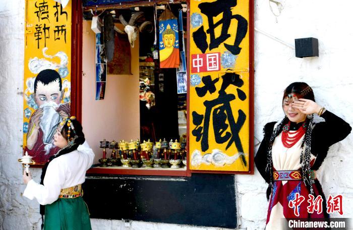 4月17日，游客身著藏式元素服裝在拉薩八廓街拍照留念。　李林 攝