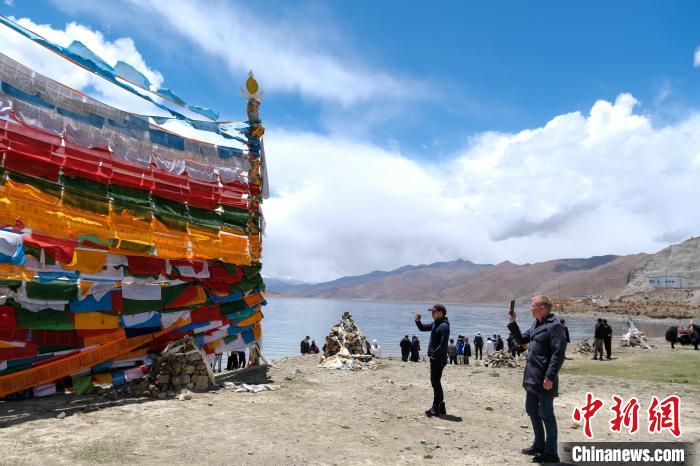 進藏參訪嘉賓在羊湖畔拍攝經(jīng)幡?！〗w波 攝