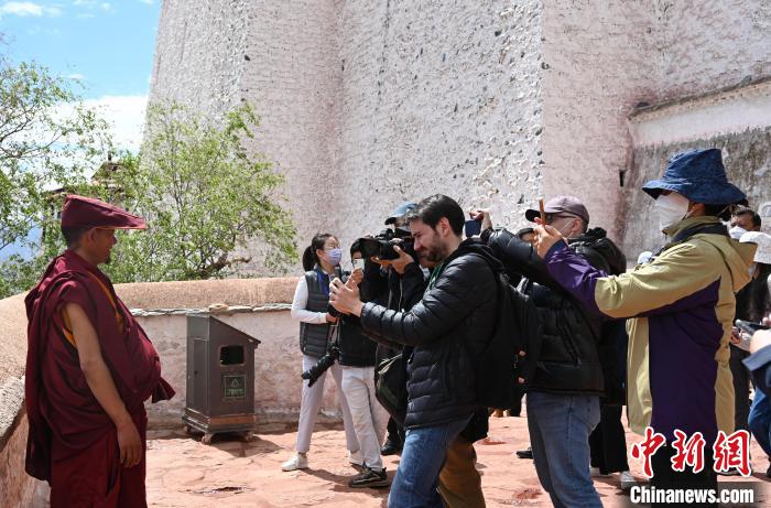 圖為中外媒體拍攝朝拜布達(dá)拉宮的僧人?！≮w朗 攝