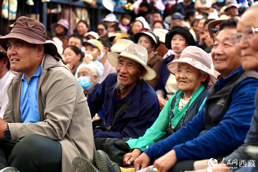 當(dāng)?shù)厝罕姾陀慰陀^看藏戲演出。