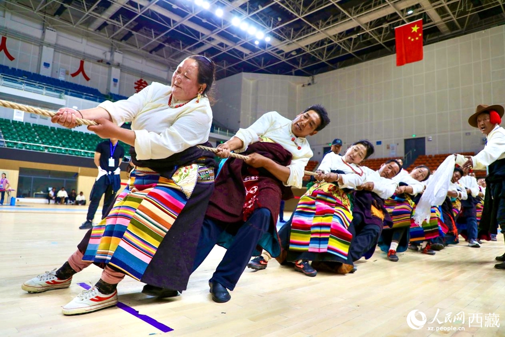 身著民族服裝的農(nóng)牧民選手在拔河比賽現(xiàn)場。