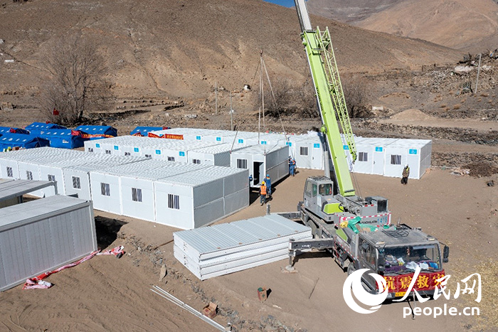 1月9日，在日喀則市定日縣長所鄉(xiāng)古榮村安置點，救援人員和施工人員合力抓緊搭建移動板房，確保受災群眾溫暖過冬。人民網(wǎng)記者 翁奇羽攝