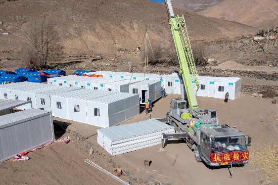 2025年1月9日，在定日縣長所鄉(xiāng)古榮村安置點(diǎn)，救援人員和施工人員合力抓緊搭建移動(dòng)板房，確保受災(zāi)群眾溫暖過冬。人民網(wǎng)記者 翁奇羽攝