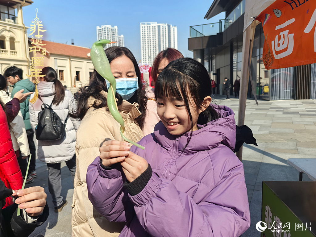 2025年1月29日，湖北武漢的新春廟會上，小朋友拿著吹制好的糖人，十分開心。人民網(wǎng)記者 張沛攝