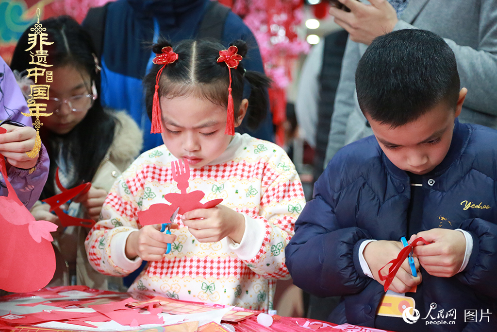 2025年1月23日，上海市青少年活動中心迎新春游園會上，小朋友們正在學習剪窗花。人民網(wǎng)記者 龔莎攝