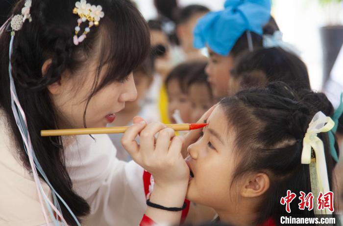 圖為老師在孩子們額頭上點(diǎn)上雄黃，驅(qū)邪辟禍。　董觀生 攝