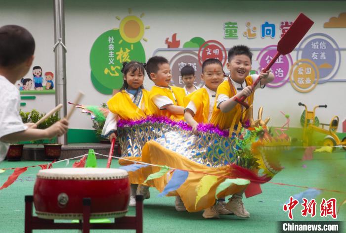 圖為龍舟賽游戲上，小伙伴們打鼓加油。　董觀生 攝