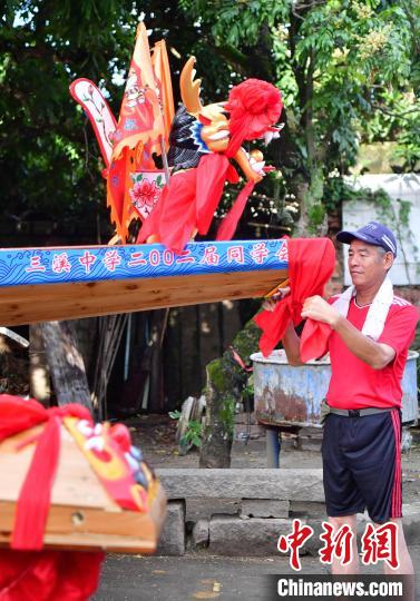 圖為5月29日，長(zhǎng)樂江田鎮(zhèn)村民為即將入水的新龍舟系紅布?！埍?攝
