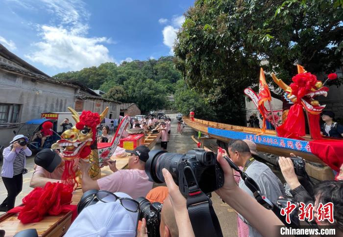 圖為5月29日，長(zhǎng)樂江田鎮(zhèn)村民為即將入水的新龍舟安裝龍頭?！埍?攝