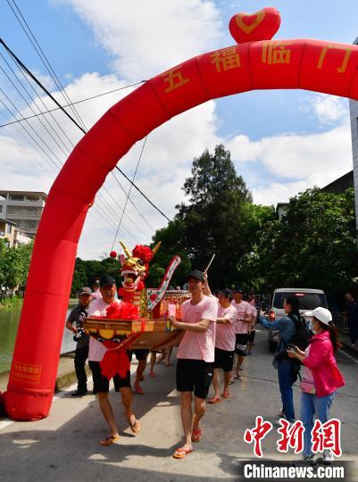 圖為5月29日，長(zhǎng)樂江田鎮(zhèn)村民們推著新龍舟前行?！埍?攝