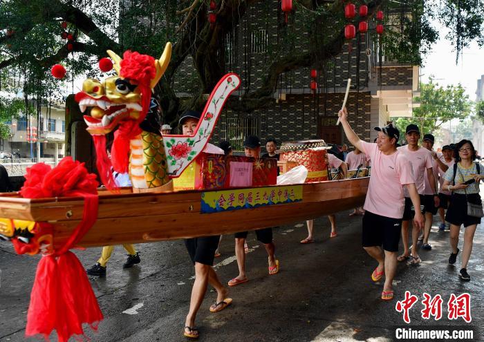 圖為5月29日，長(zhǎng)樂江田鎮(zhèn)村民們推著新龍舟前行?！埍?攝