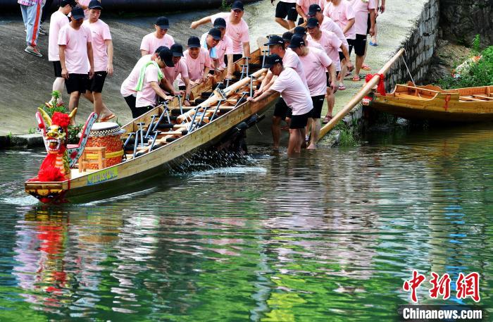 圖為5月29日，長(zhǎng)樂江田鎮(zhèn)村民們齊力推新龍舟下水?！埍?攝