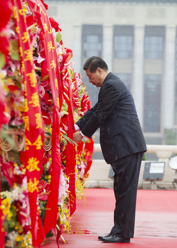 2013年10月1日上午，在首都各界代表向人民英雄紀(jì)念碑敬獻(xiàn)花籃儀式上，習(xí)近平整理花籃上的緞帶。